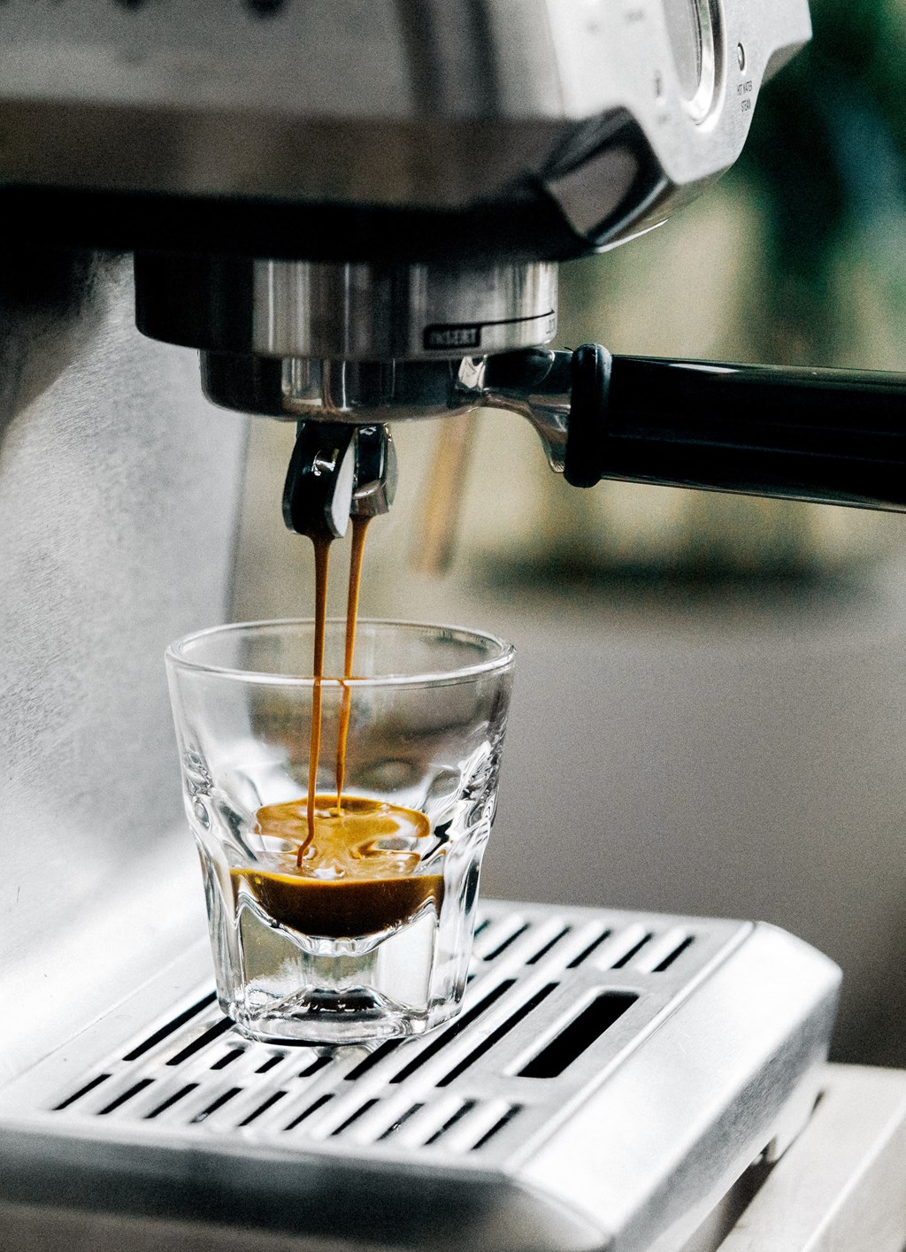 a coffee being poured into a cup in a coffee maker
