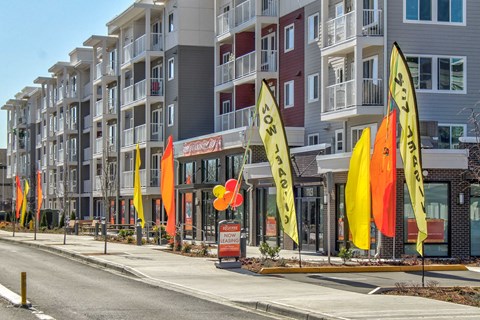 a row of yellow and red flags in front of an apartment building