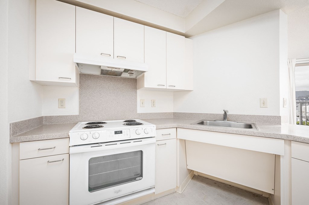 a kitchen with white cabinets and a white stove top oven