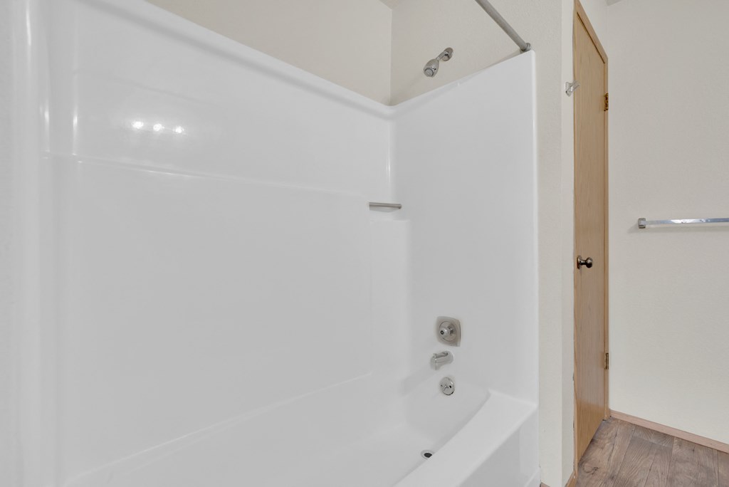 a white bathroom with a shower and a tub