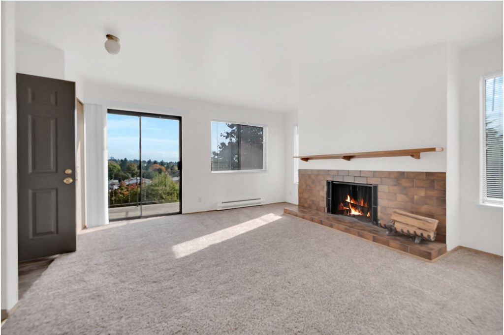 a living room with a fireplace and a door to a balcony