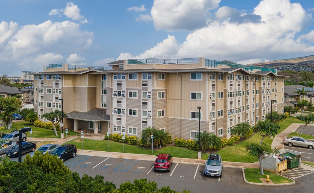 a large apartment building with cars parked in a parking lot