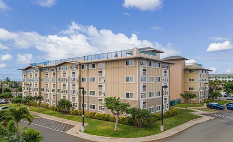 a large apartment building with a parking lot and palm trees