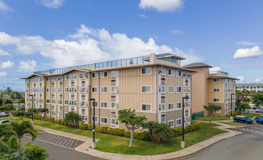 a large apartment building with a parking lot and palm trees