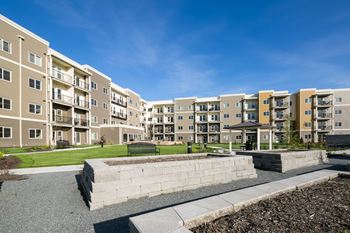 Apartment complex with a large grassy area in front.
