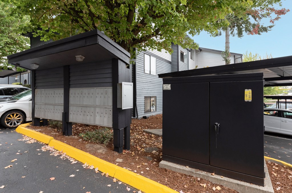 A black utility box is on the side of a road.