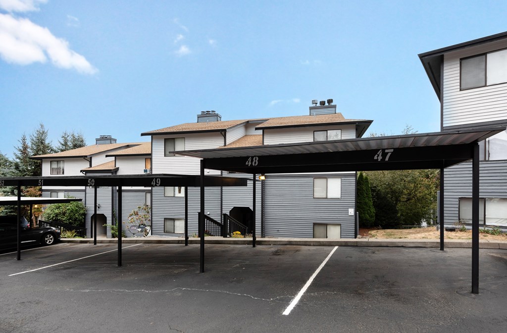 A parking lot with a car parked in front of a building with the numbers 48 and 47 on it.