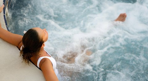A woman in a white bikini is enjoying a wave pool.