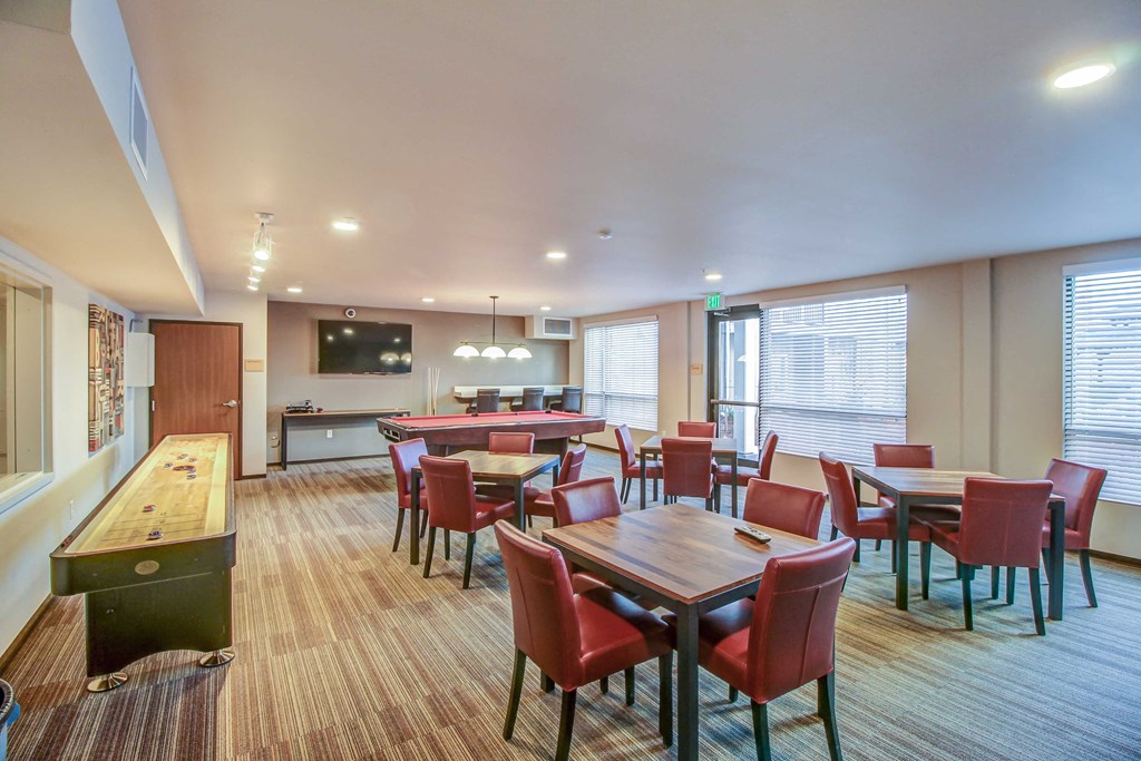a dining room with tables and chairs and a bar and a kitchen