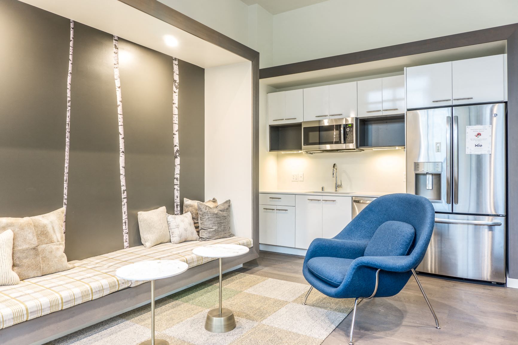 a living room with a couch and a chair and a kitchen