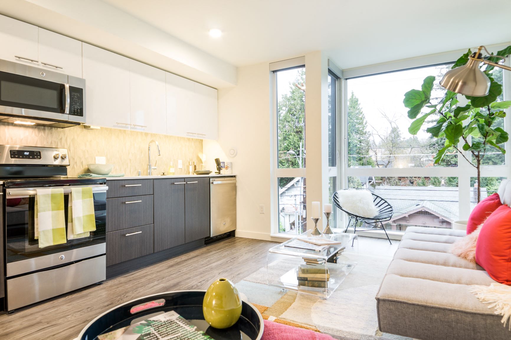 a living room with a kitchen and a large window