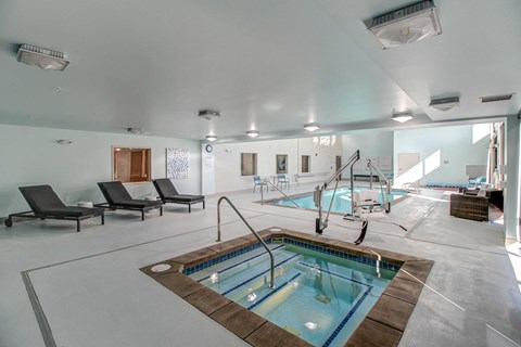a swimming pool in the center of a large room with chairs and a pool