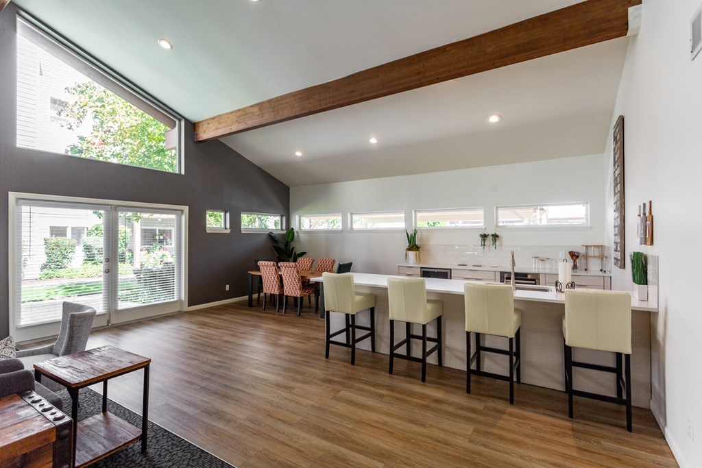 a living room with a dining room and a kitchen with a table and chairs