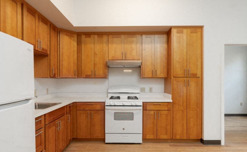 a kitchen with wooden cabinets and a white stove