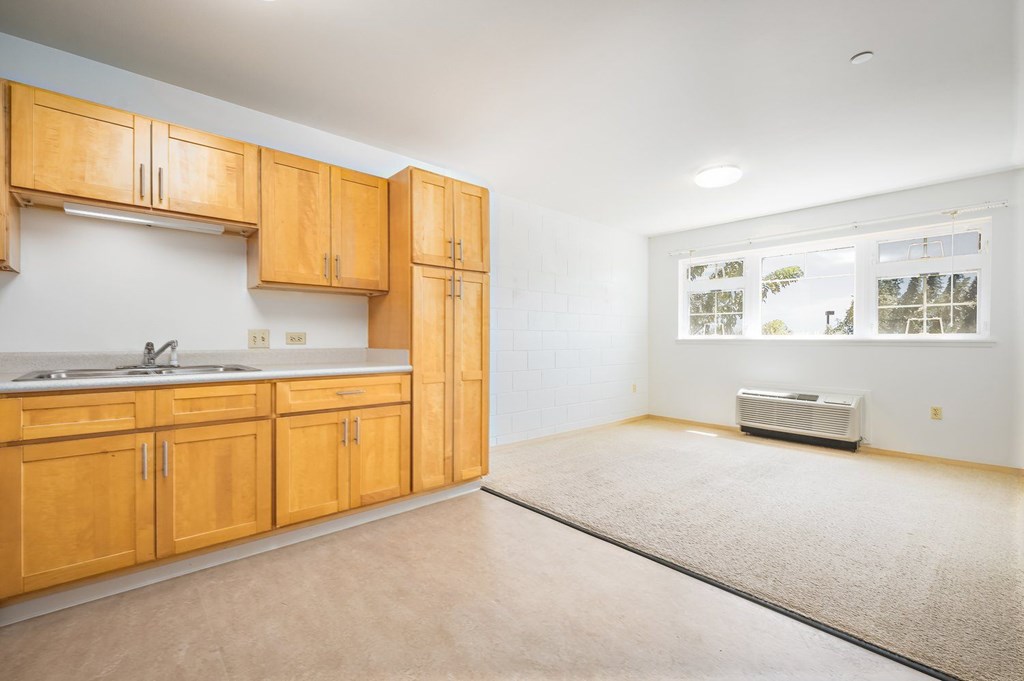 an empty kitchen with wooden cabinets and a sink