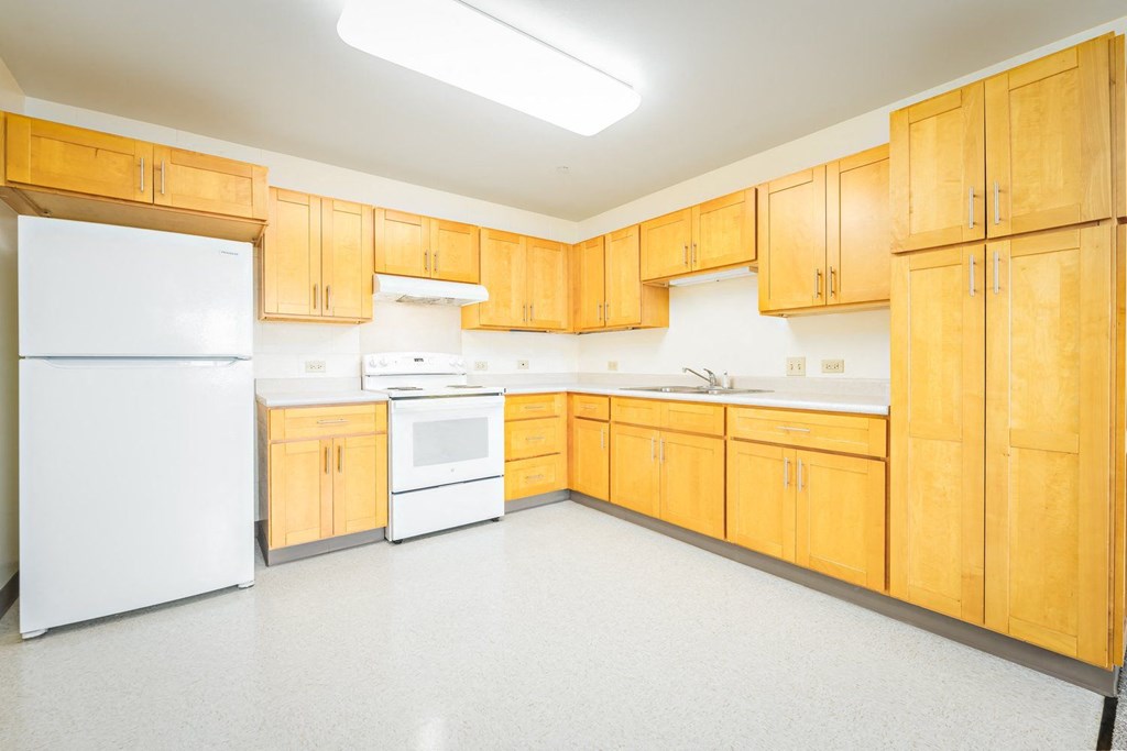 a large kitchen with white appliances and wooden cabinets