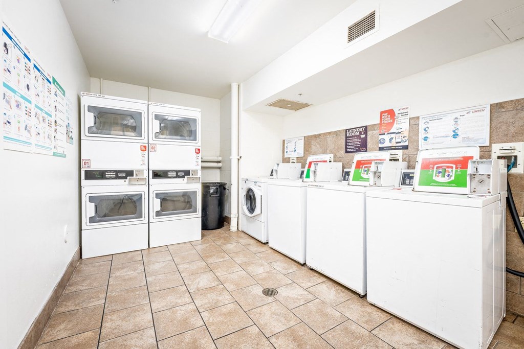 a laundry room with lots of white appliances and a tile floor