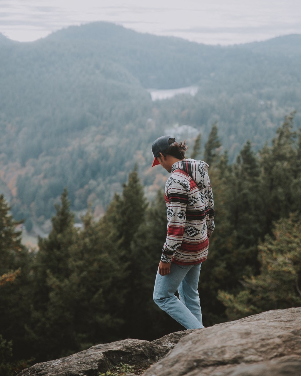 a man standing on a rock overlooking a mountain valley