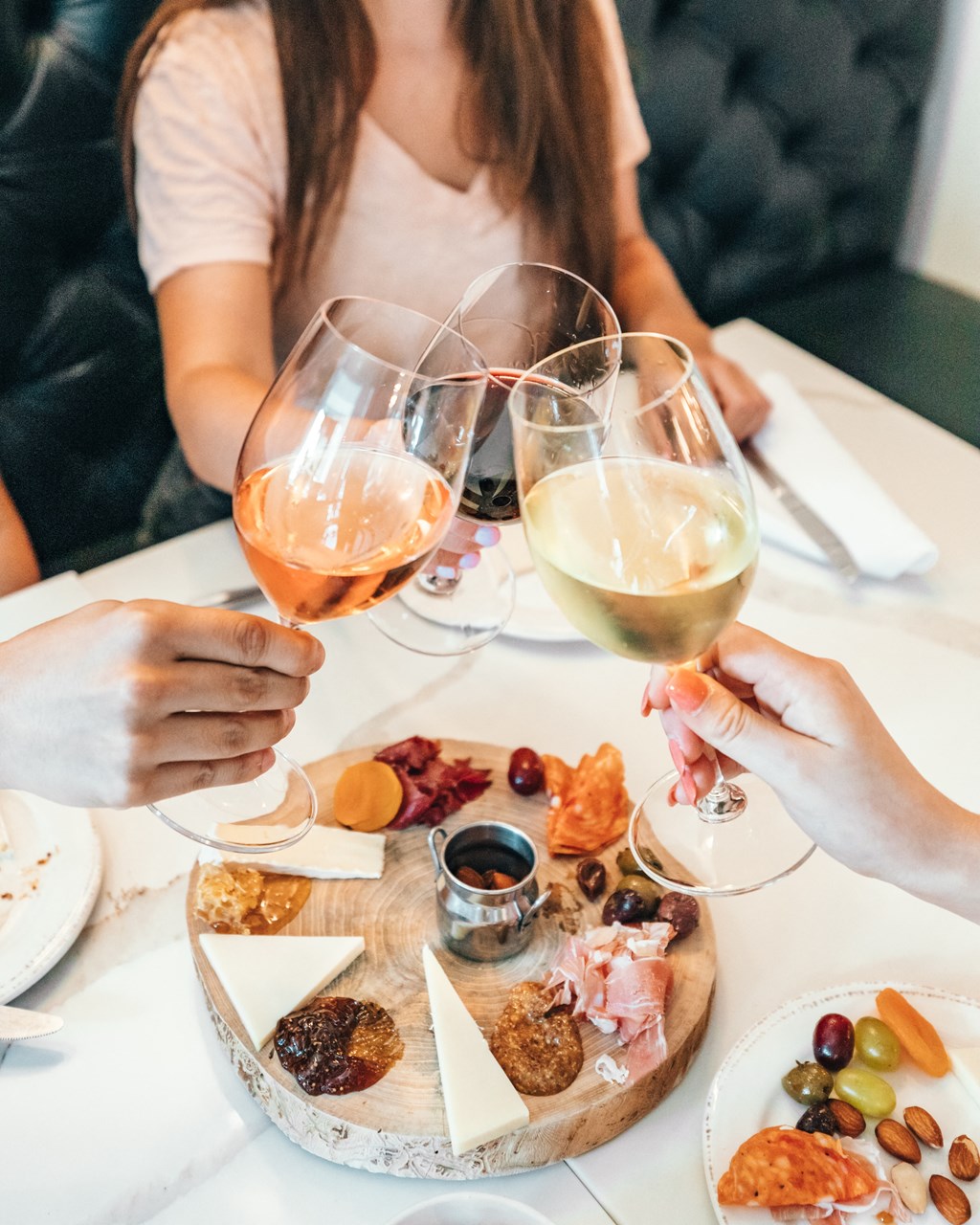 a group of people sitting around a table drinking wine and eating food