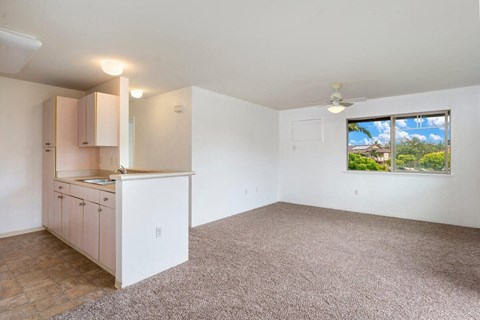 an empty kitchen and living room with a window