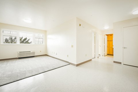 the living room and entrance of an empty house with white walls and flooring