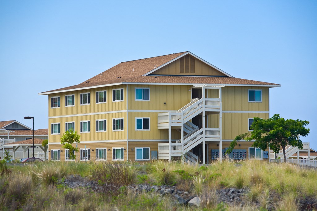 a large yellow house sitting on top of a beach