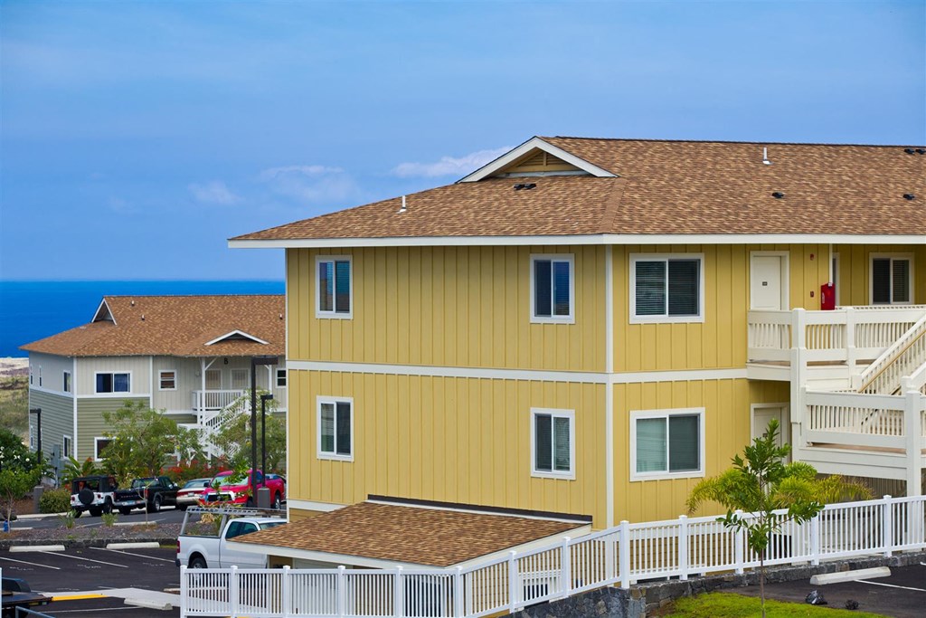 a yellow house with the ocean in the background