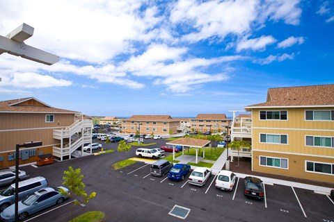 an aerial view of a parking lot with cars and buildings