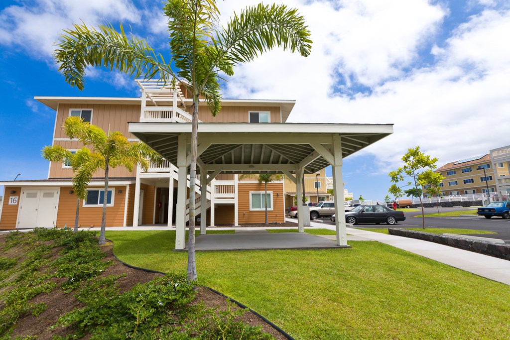 a building with a porch and a palm tree in front of it