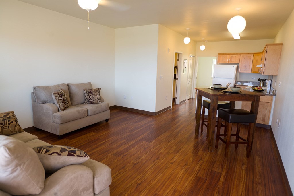 a living room and kitchen with a couch and a table