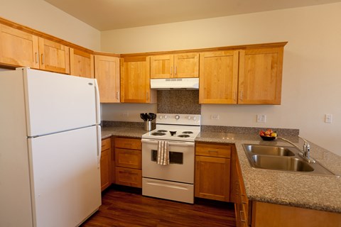 a kitchen with white appliances and wooden cabinets