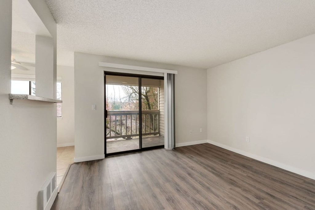 A room with a sliding glass door leading to a balcony.
