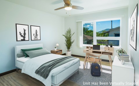 A bedroom with a bed, desk, and chair.