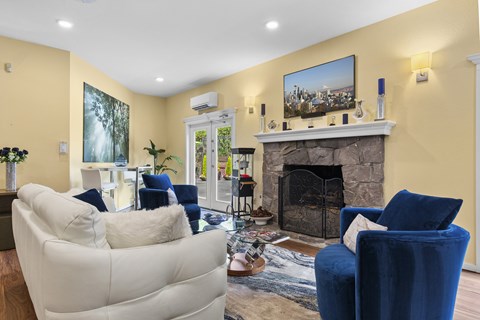 A living room with a fireplace and a painting on the wall.