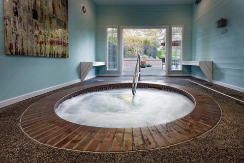 A hot tub in a room with a painting on the wall.