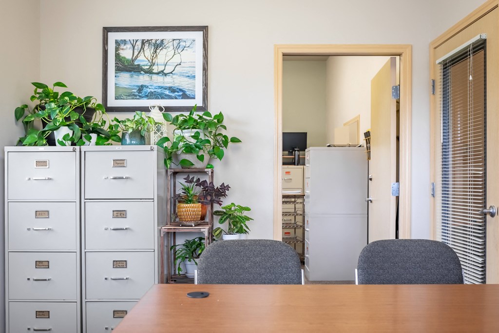 a dining room with a table and two chairs and a refrigerator