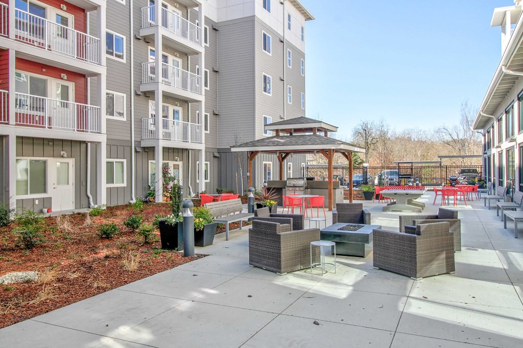 an outdoor patio with tables and chairs at an apartment building