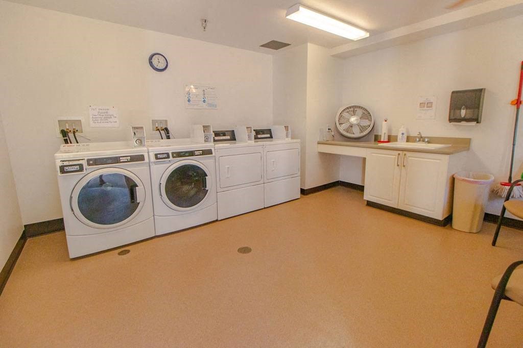a laundry room with washing machines and a sink
