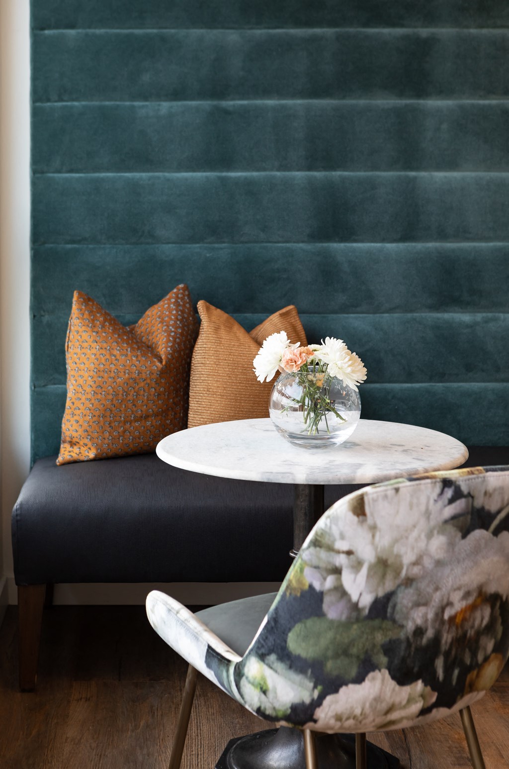 a living room with a couch and a table with a vase of flowers