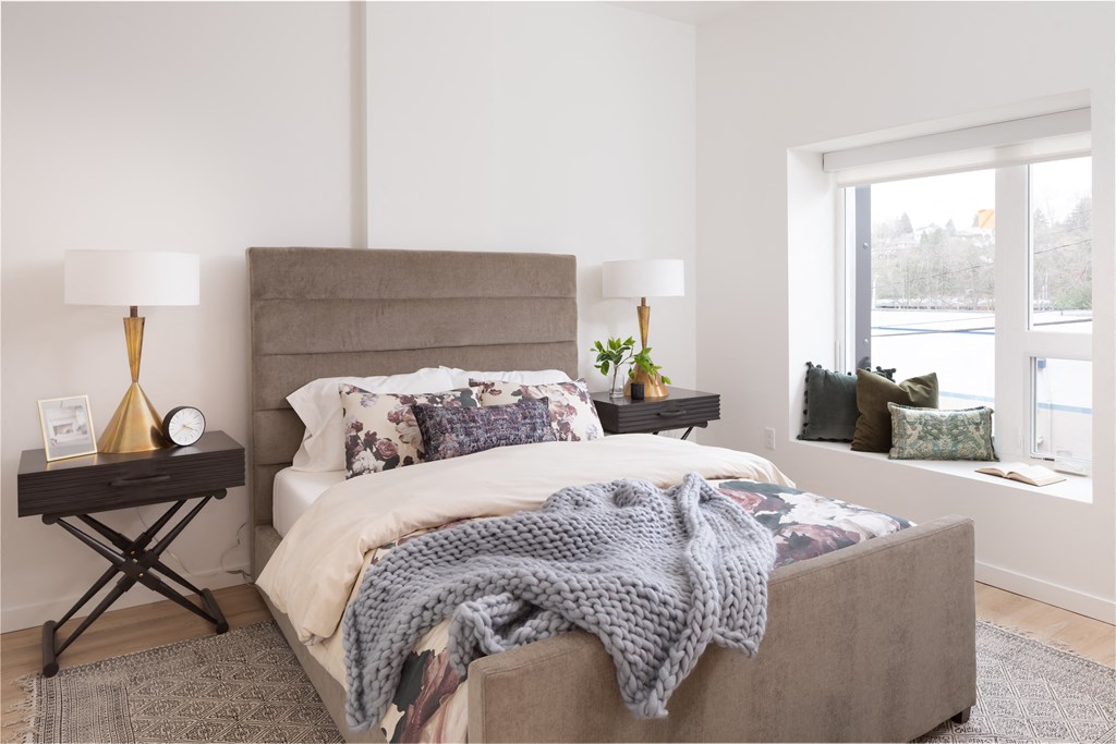 a bedroom with a bed and a large window