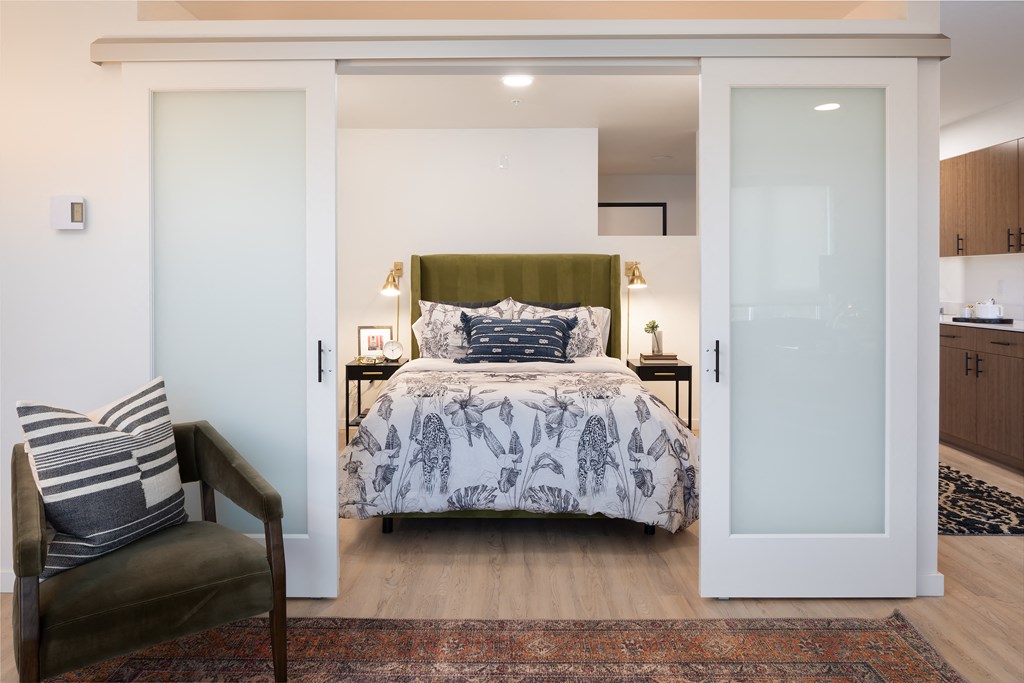 a bedroom with a bed and a chair and a closet