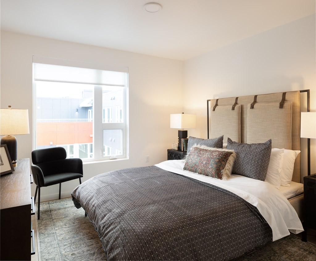 a bedroom with a bed and a large window