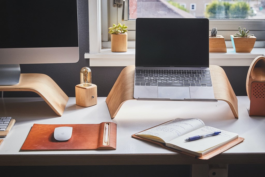 a laptop computer sitting on a desk with a notebook and mouse
