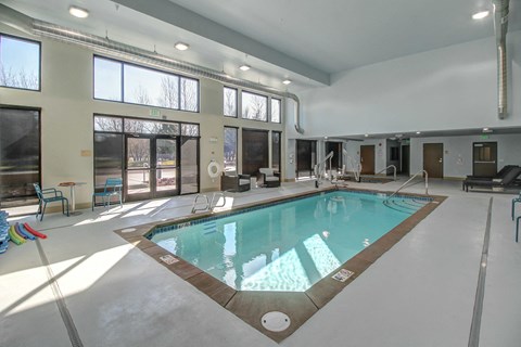 a swimming pool in the center of a room with large windows