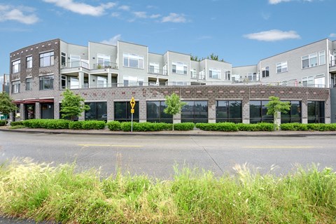 A row of modern buildings with a yellow pedestrian crossing sign in front.