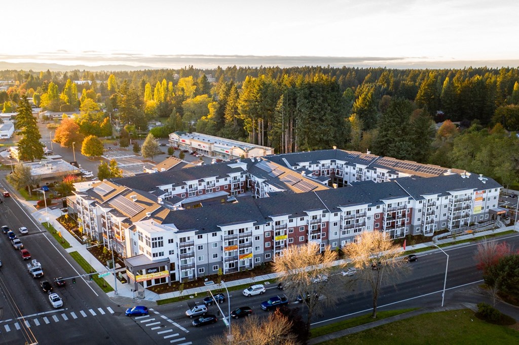 an aerial view of an apartment complex with trees in the background