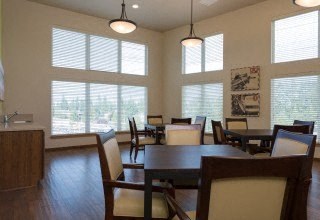 a dining room with a table and chairs and large windows