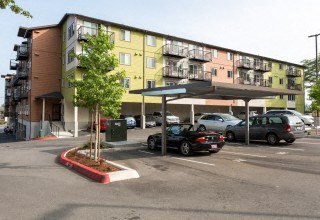 a parking lot with cars parked in front of an apartment building