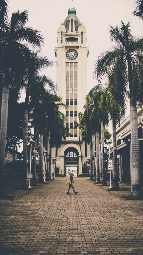 a person walking in front of a building with a clock tower