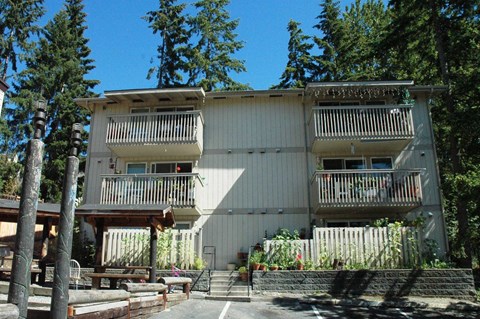 A large white building with balconies and a wooden deck in front.